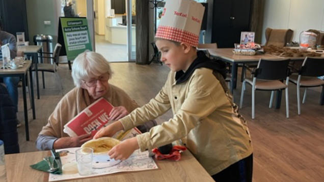 Leerlingen OBS De Tweemaster bakken pannenkoeken voor ouderen